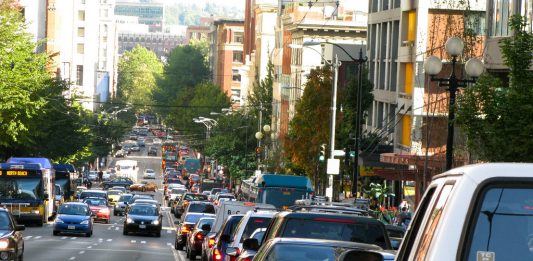 A photo of backed up car traffic on the right side of the road. Cars are approaching on the left side of the road.