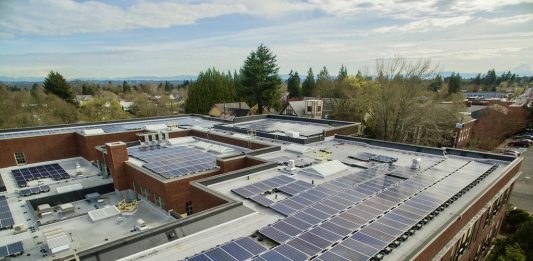 A photo of a solar array on the rooftop of a school building.