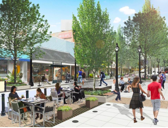 People walk on a pedestrianize street with trees