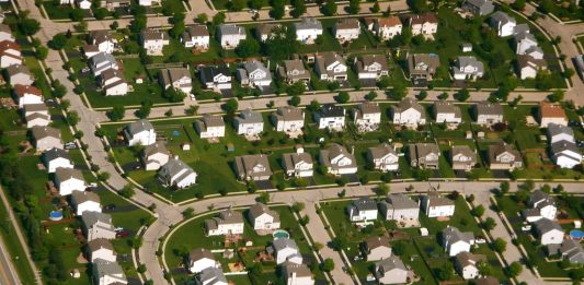 An aerial shot of cookie cutter houses in a subdivision.