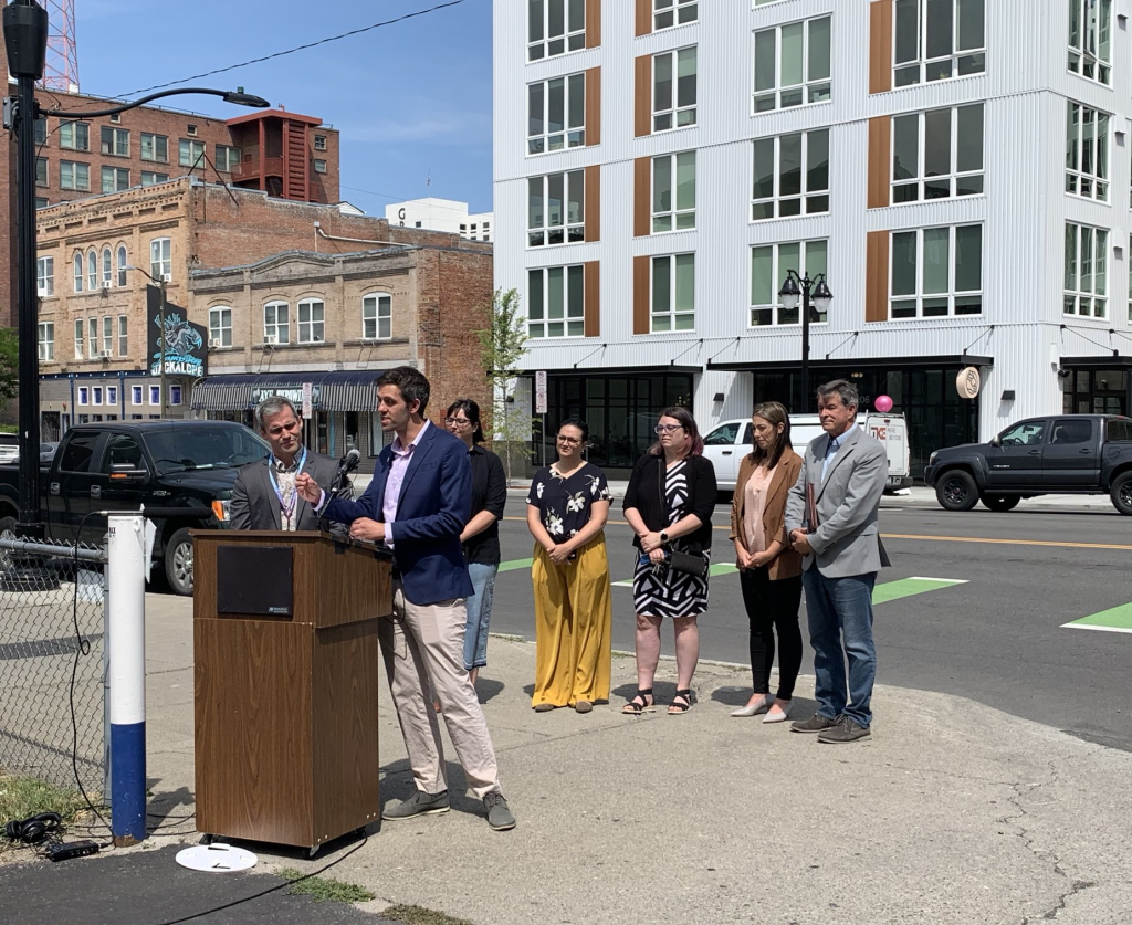 Spokane Council Member Zack Zappone and others in front of a new Spokane apartment building.