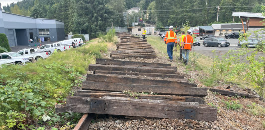 Looking down an abandoned railroad with wooden ties being removed.