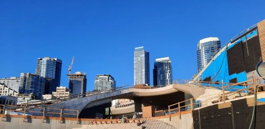 Steps are taking shape even with the concrete not yet poured. The Seattle skyline peeks in the background.