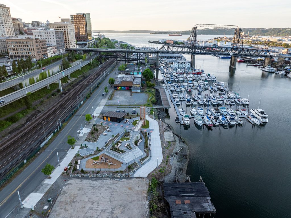 A view to the north shows the Foss Marina with lots of small boats and yachts and the Murray Morgan Memorial lift bridge carrying traffic from downtown across Foss Waterway to the Port of Tacoma. It provides no access, which allow with I-705 keeps Melanie Park disconnected.
