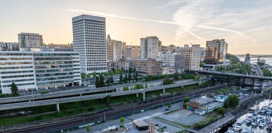 An aerial photo shows Tacoma's waterfront separated from its downtown towers by its elevated I-705 freeway.