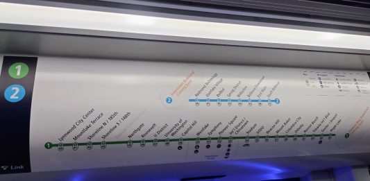 Above Link train doors are a simple map of stops with station names and numbers listed.