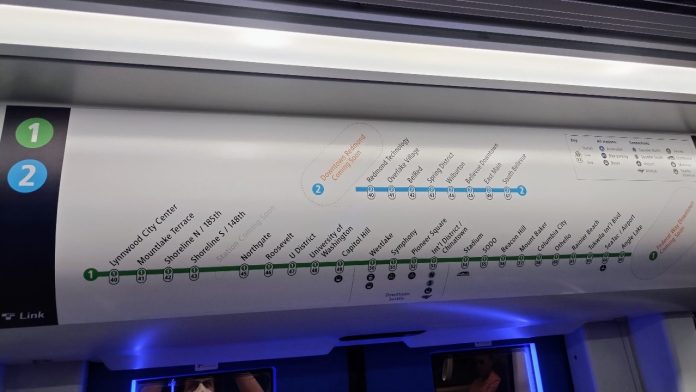 Above Link train doors are a simple map of stops with station names and numbers listed.