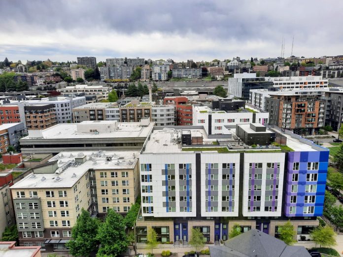 An rooftop view of rows of midrise apartments in South Lake Union with Capitol Hill in the distance.