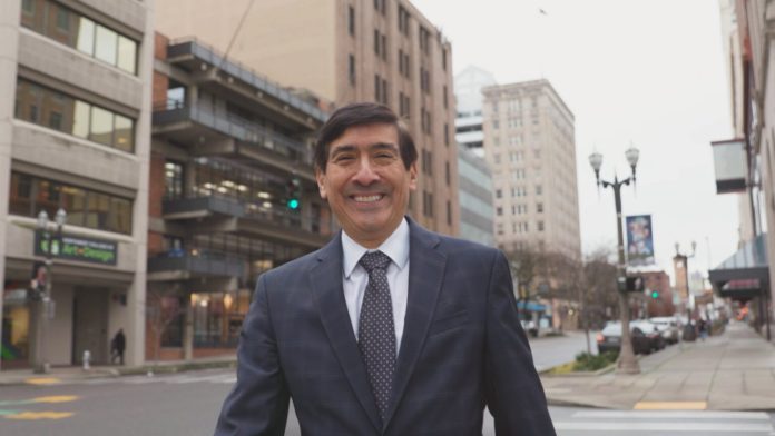 Mungia poses in a suit on a downtown Tacoma street.