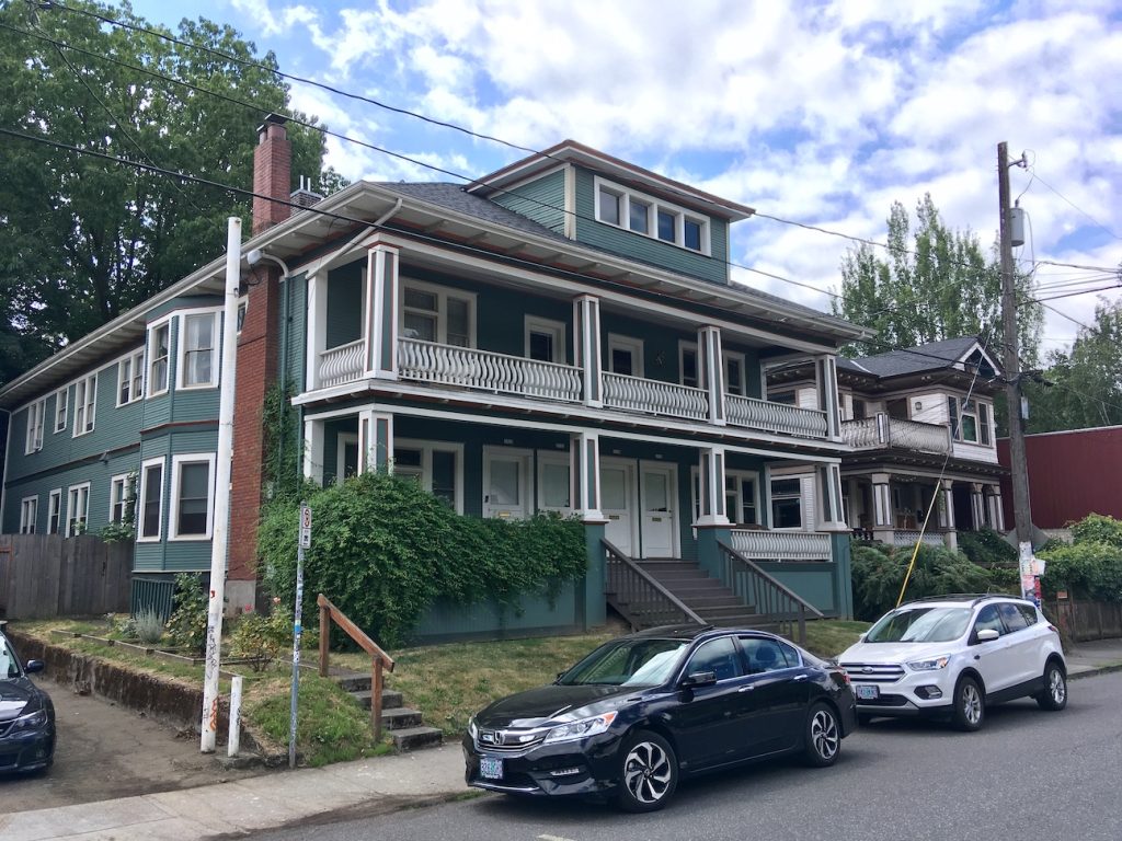 A three-story light blue build with double porches.