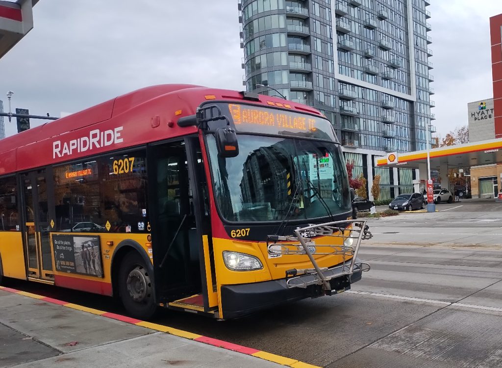 A RapidRide E stops on Denny Way in a bus lane