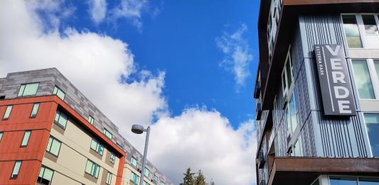 Two apartment buildings seen on a beautiful day, with one having a label of "Verve", in Redmond's Overlake neighborhood.