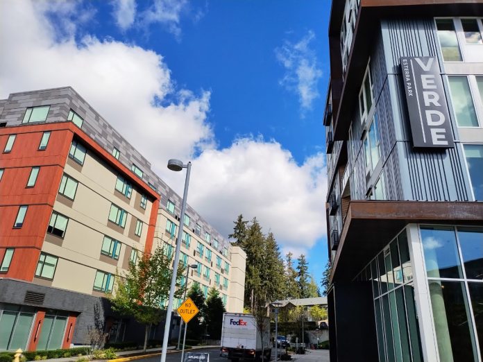 Two apartment buildings seen on a beautiful day, with one having a label of "Verve", in Redmond's Overlake neighborhood.