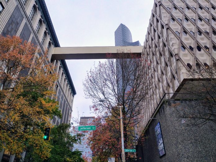 A view up at the skybridge between the King County Admin Building and the King County Courthouse, with Columbia Tower in the background