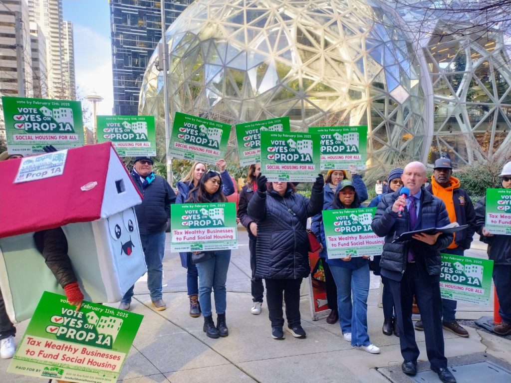 A house mascot and a dozen sign wielding advocates standing in front of the glass spheres.