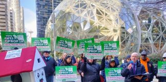 A house mascot and a dozen sign wielding advocates standing in front of the glass spheres.