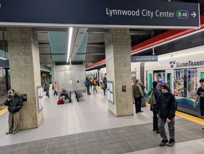 A crowded northbound train unloads at U District Station with dozens waiting on the platform for the southbound train.