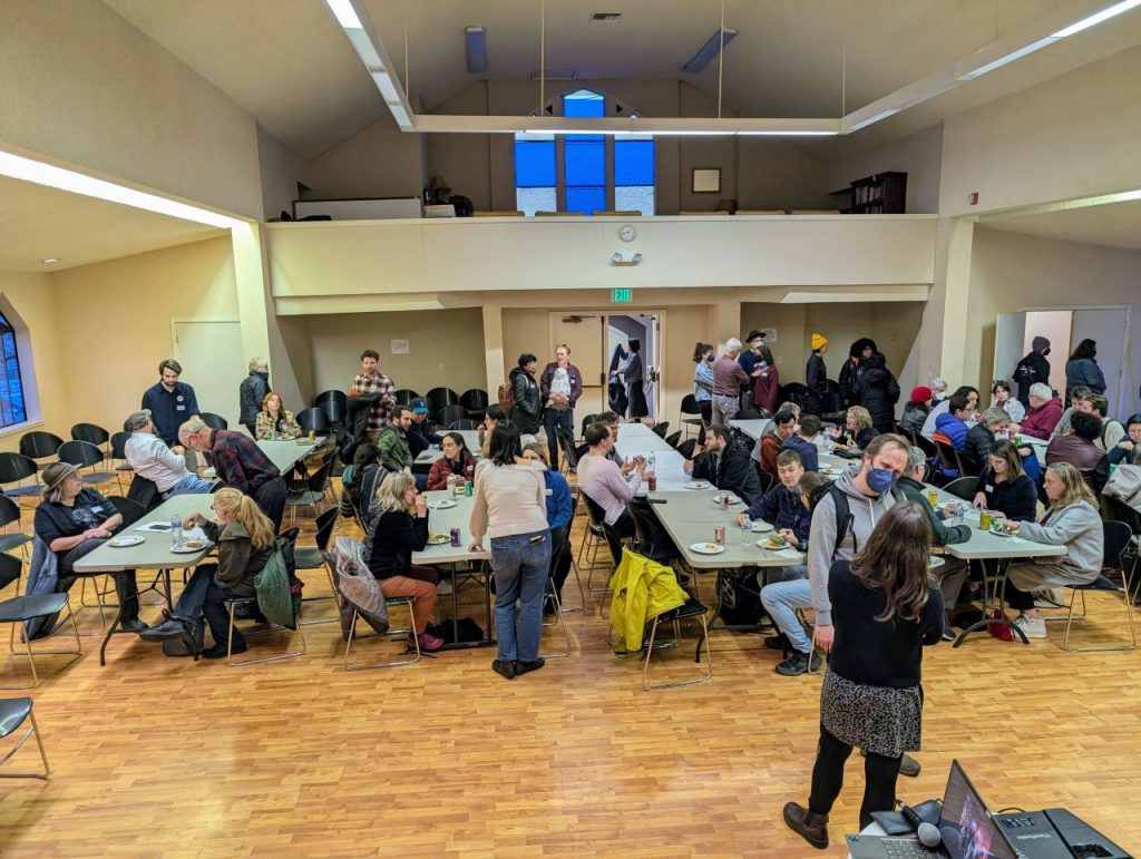 Rows of tables in a church fall are filled with volunteers from the Prop 1A campaign and people standing in line to get a plate of food.