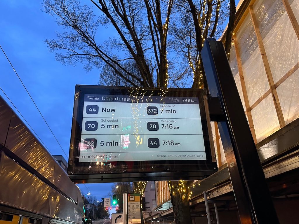 King County Metro's arrival board with a tree overhead