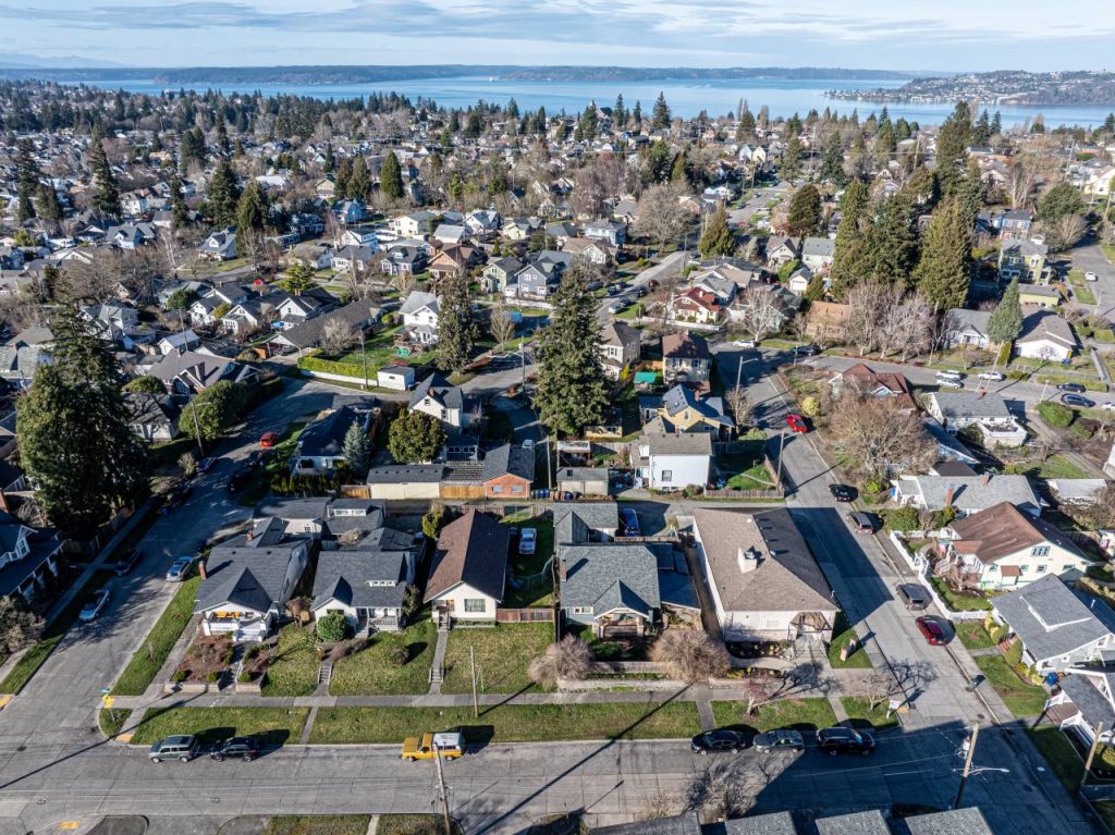 An aerial image of a single family neighborhood developed in early to mid 20th century with Puget Sound in the distance.